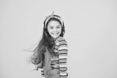 Küçük kız pozitifliğini ifade eder. Neşeli ve tasasız. Çocuk sarı fon. Yaz tatili ve tatil. Renkli bahar modası. Klasik türban stili. Mutlu çocuklar günü. Taze funky güzellik