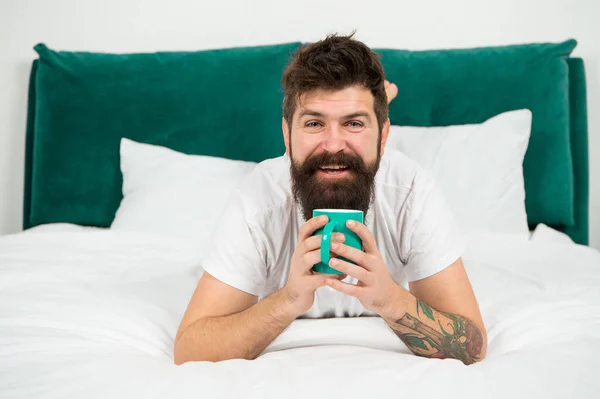 Acele etme, kahve iç. Mutlu hipster yatakta kahve içer. Sakallı adam sıcak içecekten hoşlanır. Kahvaltı içkisi. Güzel kahve. Günaydın. — Stok fotoğraf