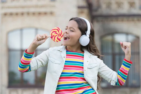 happy beauty singing in candy. kid innovating education. happy childrens day. healthy lifestyle. schoolgirl with lollipop. happy kid in headset. pupil listen music and sing song. back to school