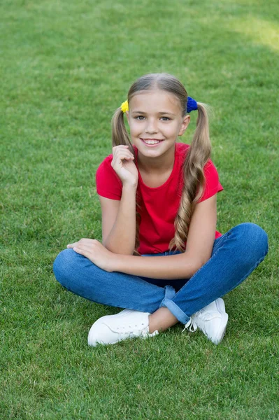 Protéjase. Niño feliz sentado en la hierba verde. Cuidado de niños y cuidado de la salud pediátrica. Productos para el cuidado de la piel. Cuidado de la piel de verano. Cosméticos para el cuidado del cabello. Cuidado del cabello. Salón de belleza. Cuídate mucho. — Foto de Stock