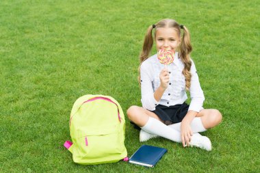 Bilgi günü. Modern okul eğitimi. Mutlu çocukluk. Kitaplı genç kız. Küçük tatlı kız tatlı lolipop yiyor. Çocuklar için edebiyat eğitimi. belge dizini ile öğren