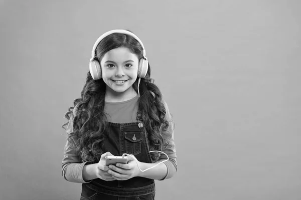 Niña pequeña escuchar música auriculares modernos y teléfonos inteligentes. Entretenimiento online. Aplicaciones de música gratis. Escucha gratis. Obtener suscripción a una cuenta de música. Disfruta del concepto musical. Disfruta del sonido perfecto — Foto de Stock