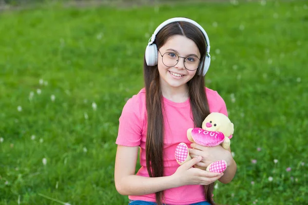 Un gros câlin d'ours pour toi. Valentines fille tenir ours en peluche sur l'herbe verte. Un petit enfant a reçu un cadeau de Saint-Valentin. Fête de la Saint-Valentin. Célébrez l'amour cette Saint Valentin — Photo