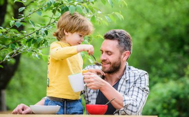 Sabah kahvaltısı. Vejetaryen diyeti. Babalar günün kutlu olsun. Babasıyla küçük çocuk mısır gevreği yiyor. Sağlıklı yemek ve diyet. Süt ürünleri. Baba oğul yemek yiyor. Aile yemeği zamanı. Ailem benim ilham kaynağım.