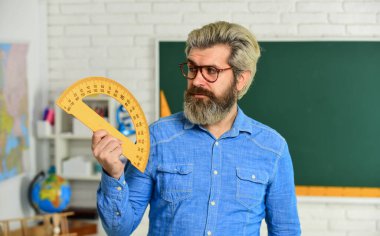 Matematik dersi. Eğitim konsepti. Yetenekli pedagog. Özel ders. Okula dönelim. Matematik çalış. Erkek öğretmen okul projelerine rehberlik ediyor. Modern bilim okulu. Gözlüklü olgun sakallı öğretmen.