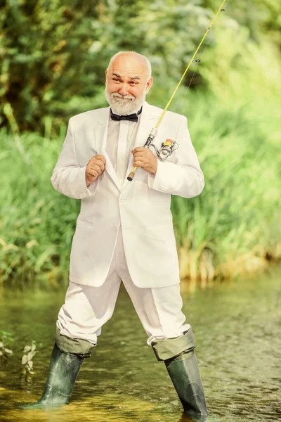 Arbetar överallt. Fiskare i formell kostym. Lyckad fångst. affärsframgångar. moget mansfiske. Fiskaren firar pensioneringen. bra produktion. pensionerad affärsman. Bra vinst. hobby rekreation — Stockfoto