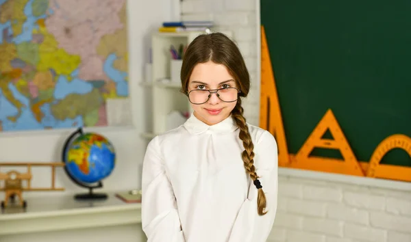 Einführung neuer Arbeitseinheiten. Das Mädchen trägt eine Brille. Zurück zum Schulkonzept. Buch lesen als Hobby. Bildung und Kinderliteratur. Romantische Schülerin im Klassenzimmer. Liebenswerter Schulnerd — Stockfoto
