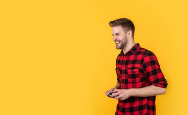 Adam video oyunu oynuyor. Kumanda konsolu kumandası. TV 'de futbol ya da futbol maçı. Bilgisayar oyunu oynuyorum. Genç adam video oyunu oynamak için oyun kumandasını tutuyor. Evde dinlen. cpy alanı