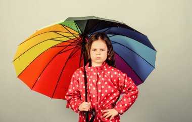 Yağmurlu hava ve uygun giysiler. Yağmurlu gün eğlencesi. Şemsiye altında iyi yürüyüşler. Yağmurdan sonra her zaman gökkuşağı vardır. Yağmur konseptinin tadını çıkar Sonbahar sezonu. Çocuk mutlu renkli gökkuşağı şemsiyesi tutun