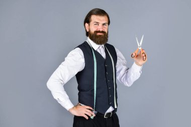 Erkekler için tasarım yapan bir adam. Başarılı sartor çalışmaya hazır. Resmi ve ofis tarzı. Mezura ve makasla terzi. Erkek kıyafetleri terziliği yapan adam. Acımasız adam moda tasarımcısı.