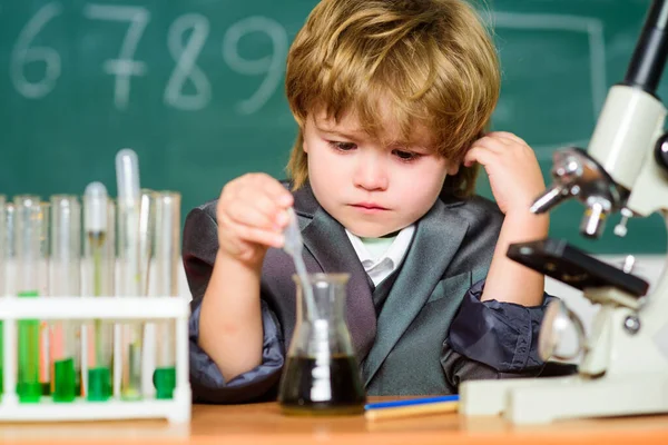 School education. Explore biological molecules. Toddler genius baby. Boy near microscope and test tubes in school classroom. Science concept. Gifted child and wunderkind. Kid study chemistry school