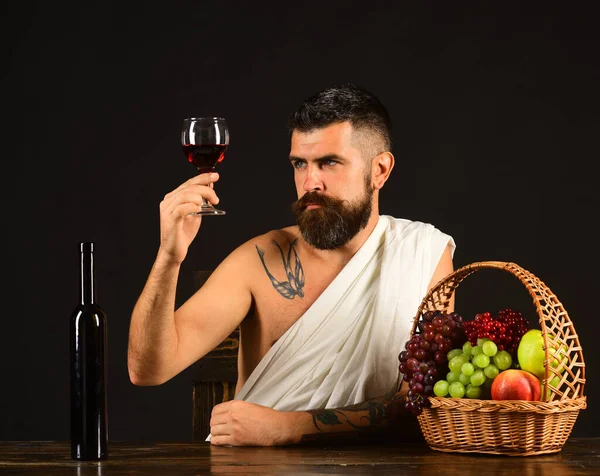 Winemaking and degustation concept. God Bacchus with attentive face