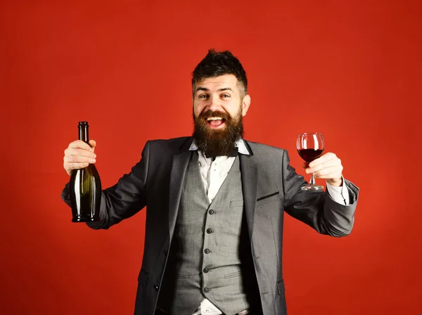 Degustator with beard and expensive wine on red background