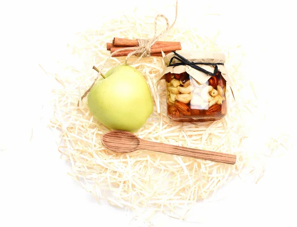 Jablka, ořechy ve sklenici s řemeslným papírem na bílém — Stock fotografie