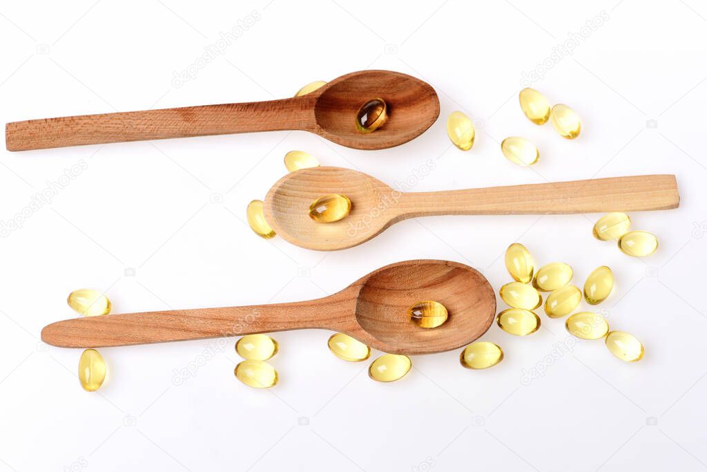 Natural medicines and wooden spoons. Omega 3 pills and cooking utensils.