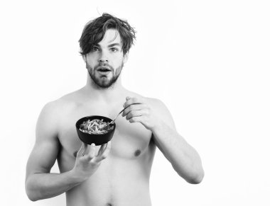 Kafkas seksi genç maço elinde makarna ile siyah kase tutuyor.