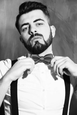 Stüdyo duvarında ciddi bir yüzü olan sakallı bir adam.