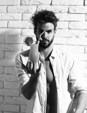 Beyaz tuğla duvarda yakışıklı, sakallı, maço seksi bir adam.