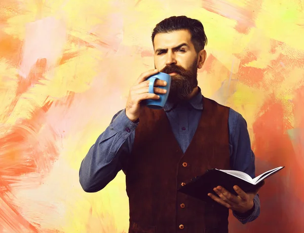 Barbuto brutale hipster caucasico con tazza di caffè e notebook nero — Foto Stock