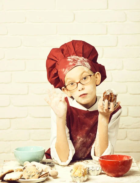 Заплямований милий кухар хлопчик-кухар на фоні білої цегляної стіни — стокове фото