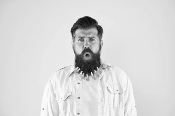 Incredibile espressione facciale. Maschio barbuto faccia da vicino. Che bel viso. Peli sul viso. Assolutamente no. Uomo stressato con grande barba tenuto insieme con un sacco di mollette. Concetto scioccante e sorprendente — Foto Stock