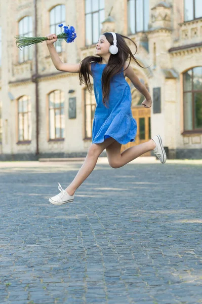 Always energetic. Happy girl in energetic jump outdoors. Energetic mood. Fresh vibes. Music and entertainment. Summer vacation and holidays. Leisure and free time. Energetic and unstoppable