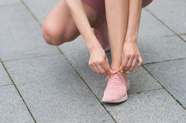 균형잡혀 있는 편안 함과 스타일. 여성 손이 스포츠용 신발을 대신 한다. 신발 끈을 묶는 일. 신발을 신는 여성들. 경기장 바닥에 신발을 신고 있다. 운동용 신발. 영업소요. 건강과 훈련. 건강 한 생활 방식 — 스톡 사진