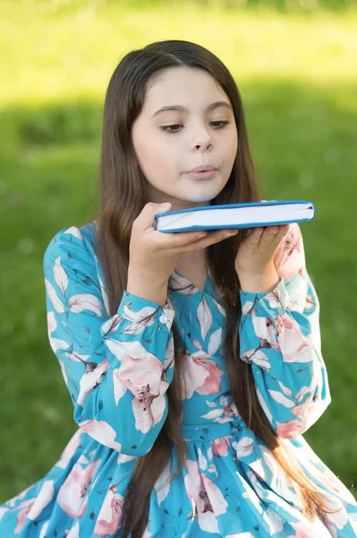 Blowing dust off book. Little child hold book outdoors. Small reader in summer park. Library book. Fantasy and fiction. Childrens literature. Childhood reading. Book crossing — Stock Photo, Image