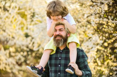 Mutlu bir aile. Babalık mutluluğu. Babalar Günü. Dünya günü. Doğada yaşayan küçük bir çocuk ve baba. Hippi ve küçük oğlu. Mutluluk kavramı. Bahar yürüyüşü. Ekoloji ve çevre. Basit mutluluk.