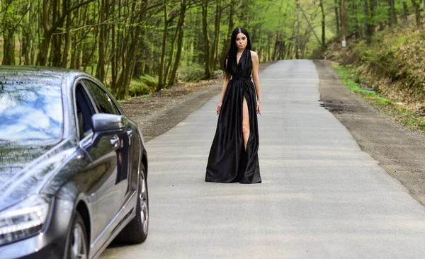 Sexy girl elegant dress at road. Escort concept. Glamorous girl and luxury car. Escort and sexual services. Driver girl. Beauty and fashion. Woman in black dress. Elegant lady escort service worker