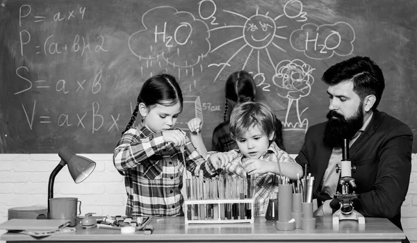 Σχολική εκπαίδευση. Λέσχη Χημείας. Ανακαλύψτε και εξερευνήστε μαζί τις ιδιότητες των ουσιών. Ενδιαφέροντα και θεματική λέσχη. Δάσκαλοι και μαθητές δοκιμάζουν σωλήνες στην τάξη. Μεγαλύτερα παιδιά βοηθούν μικρότερα — Φωτογραφία Αρχείου