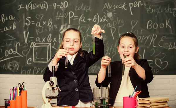 Базове знання хімії. Дівчата вивчають хімію. Зробити вивчення хімії цікавим. Мікроскоп і пробірки на столі. Концепція освітнього експерименту. Будьте обережні, виконуючи хімічну реакцію — стокове фото