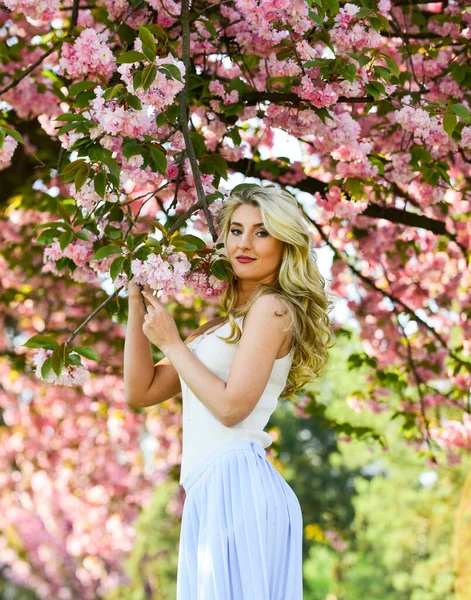 Uyum ve kadın enerjisi. Bahar sembolü Çiçeklerin kadınları neden her zaman mutlu ettiğini. Mutlu bahar günleri. Kız bahçede sakura çiçeğinin tadını çıkarıyor. Bahar çiçeği açan ağaç. Kiraz ağacı. Çiçek aroması