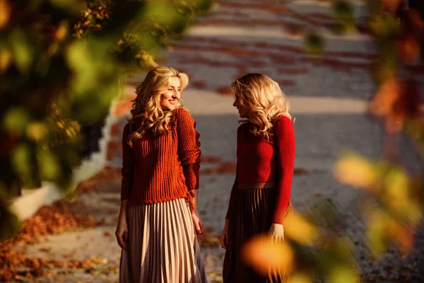 Femininity and tenderness. Women walking in autumn park. Pleated skirt fashion trend. Friends girls. Autumn stylish outfit. Fall fashion. Adorable ladies enjoy sunny autumn day. Fashionable clothes