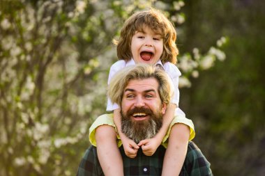 Doğada yaşayan küçük bir çocuk ve baba. Hippi ve küçük oğlu. Birlikte bahçeyi keşfediyoruz. Mutluluk kavramı. Basit mutluluk. Mutlu bir aile. Bahar yürüyüşü. Babalık mutluluğu. Babalar Günü
