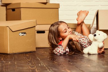 Yeni bir yaşam tarzı kirala. Mutlu çocuk karton kutusu. Taşınma konsepti. Yeni daire. Yeni bir yaşam alanı satın almak. Karton kutular yeni eve taşınıyor. Oyuncak ile mutlu küçük kız