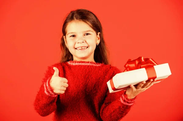 Día de boxeo. Una niña pequeña sostiene la caja de regalo. Niño mantenga la caja actual fondo rojo. Centro comercial. Chica del cumpleaños. Feliz Navidad y felices fiestas. Compras de regalos de Navidad. Paquete regalo. Sueños preciados —  Fotos de Stock
