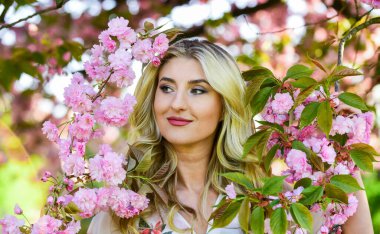 Mutlu bahar günleri. Uyum ve kadın enerjisi. Bahar sembolü Kız bahçedeki sakuranın tadını çıkarıyor. Kiraz ağacı. İyi titreşimler. Çiçek aroması. Bahar çiçeği açan ağaç. Çiçeklerin kadınları neden her zaman mutlu ettiğini.