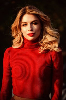 Kadınlık ve şefkat. Sonbahar tarzı kıyafetler. Sonbahar modası. Sevimli kız geçen güneş ışınlarının tadını çıkarıyor. Şık kıyafetler. Sonbahar parkında yürüyen bir kadın. Samimi örgü giysiler. Örgü süveter