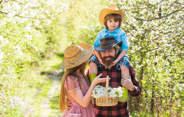 First flowers. Happy family enjoy spring time. Family of three in garden. Family vacation. Family life. Spring nature. Blossoming season — Stock Photo, Image
