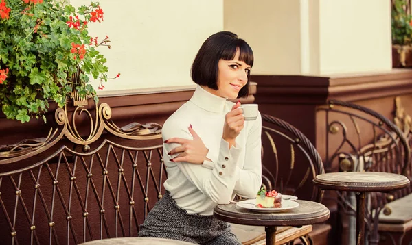 Tempo agradável e relaxamento. Delicioso bolo gourmet. Menina relaxar café com sobremesa bolo. Conceito gourmet. Ela adora doces. Mulher atraente elegante morena comer bolo gourmet café terraço fundo — Fotografia de Stock