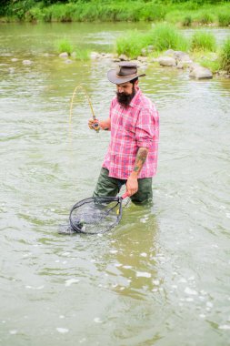 Balık Bağımlılığı. Yaz haftasonu. Büyük balık avı. Elinde olta olan balıkçı. Olgun adam balık tutuyor. Balık tutan adam. Hobi ve spor aktiviteleri. Pothunter. Sudaki sakallı balıkçı