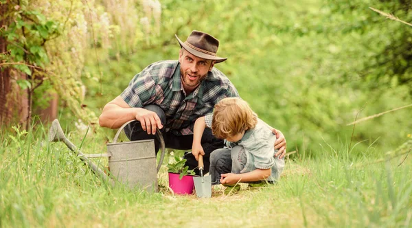 Growing plants. Take care of plants. Boy and father in nature with watering can. Gardening tools. Planting flowers. Dad teaching little son care plants. Little helper in garden. Make planet greener — Stock Photo, Image