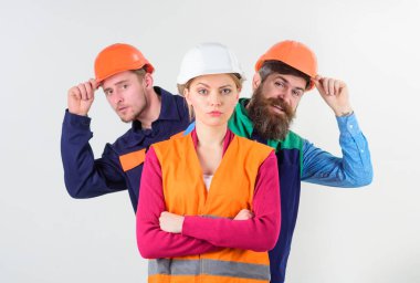 Kadın, kasklı lider ve ciddi bir yüz duruşu.