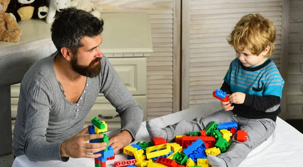 Папа и ребенок строят пластиковые блоки. Мужчина и мальчик — стоковое фото