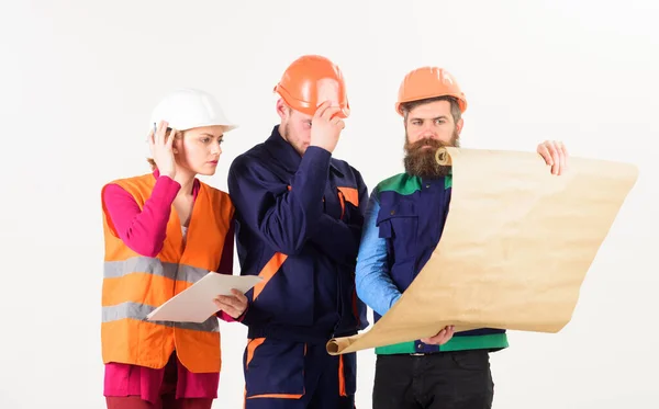 Hombres y mujeres en cascos, arquitectos en rostros ocupados — Foto de Stock