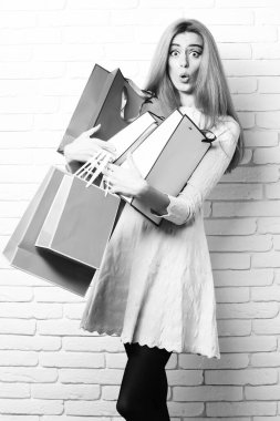 Brick Wall stüdyosunun arka planında renkli askıları olan sürpriz bir kız.