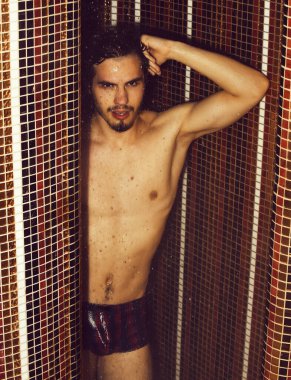 Yakışıklı kaslı seksi adam duşta yıkanıyor.
