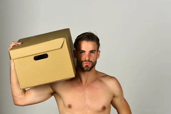 Kerl mit Karton auf Schulter auf grauem Hintergrund — Stockfoto