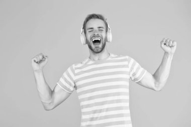 Müzik beni mutlu ediyor. Mutlu adam sarı arka planda müzik dinliyor. Yakışıklı adam kulaklıkla melodi çalmaktan hoşlanıyor. Mutlu müzik. Zevk ve neşe. Eğlence ve eğlence. Mutlu yeni karışımlar. Süper vuruş.